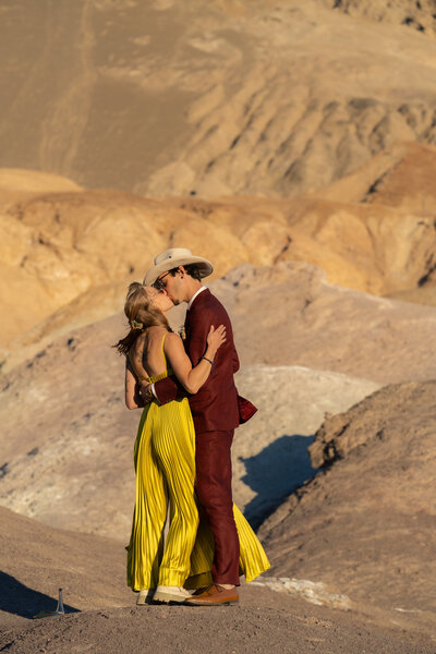 A couple kissing in a desert area