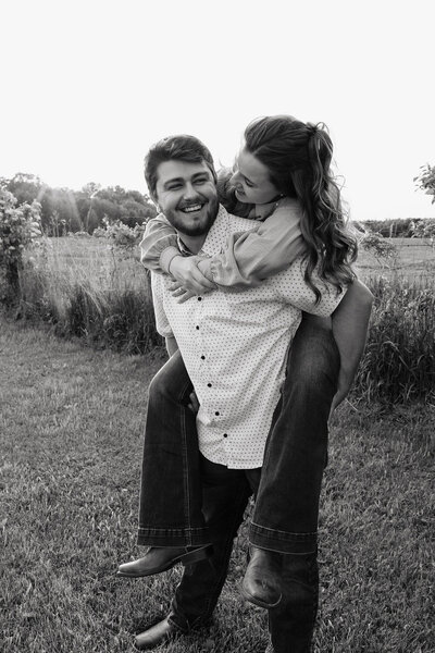 Black and white image of a couple celebrating their engagement on the beaches of a lake in Minnesota