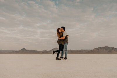 man kisses woman on cheek in sand