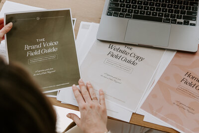 A woman holding a green brand voice guide printout