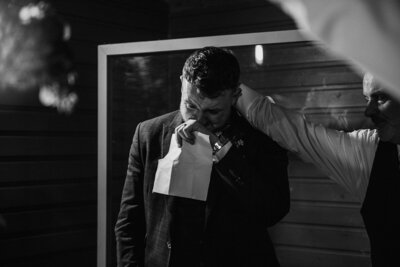 Groom shedding a tear during his speech and getting comforted by his father in law