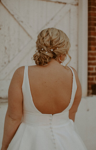 Bride with wavy braided wedding hair holding a bouquet of earth-toned flowers