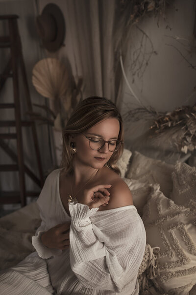 Portrait de femme qui a les yeux fermés et vêtue d'une robe en coton blanche