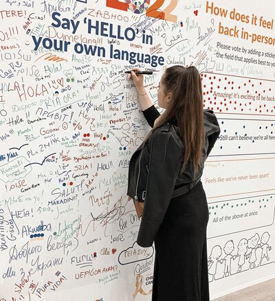 Founder at a conference writing something on the welcome wall