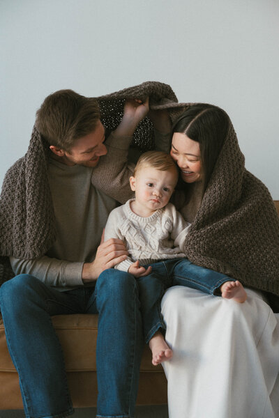 Family of four  is sitting down on the grass