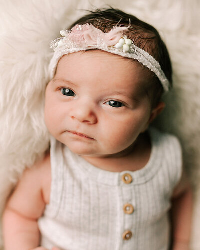 Adorable newborn baby girl in a beautiful lace headband photographed by Chelsey Kae Photography