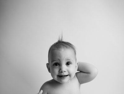 Professional headshot in Austin, Texas, showcasing a confident individual with a clean, polished look, captured with soft lighting against a simple, neutral background.
