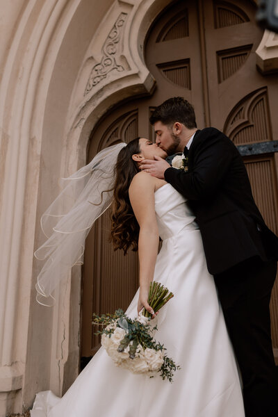 bride and groom kissing under veil