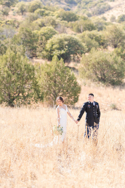 bride and groom walking through canyon field at Sierra Vista elopement ceremony