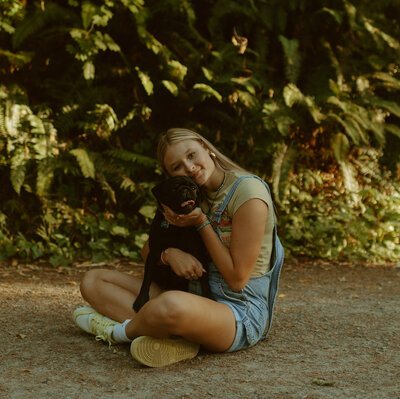 girl sitting with dog in washington nature park