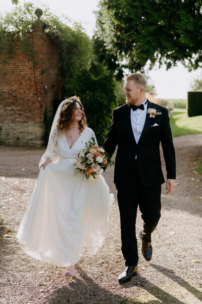 Groom giving bride a piggyback ride at outdoor reception