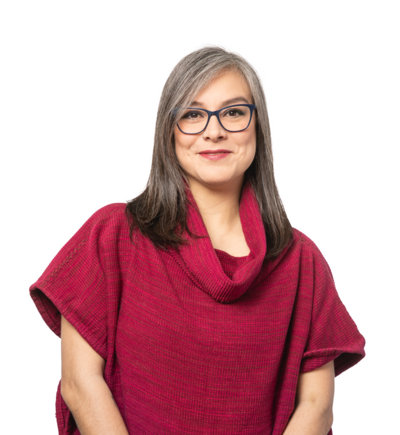 Native Latinx person with shoulder-lenth grey hair, wearing a deep pink sweater