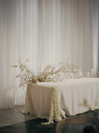 stunning, whimsical white orchid floral installation escort table, ethereal drapery, Michigan film wedding photographer