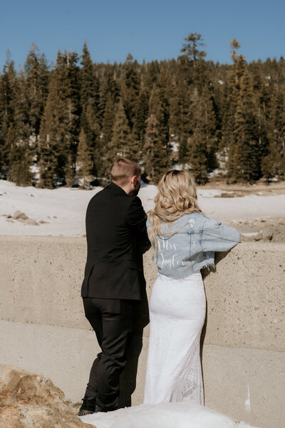 BRIDE AND GROOM REFLECTING ON THEIR SNOWY MOUNTAIN ELOPEMENT