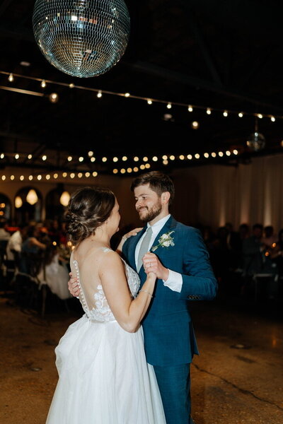 Bride and groom smiling while doing their dance