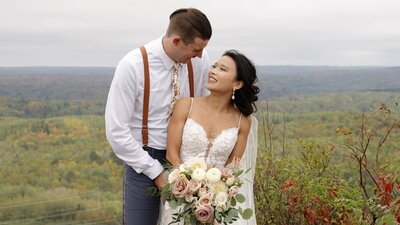 Sunset photo session at Des Moines, IA courthouse.Couple in wedding attire standing  with Des Moines Skyline behind them.