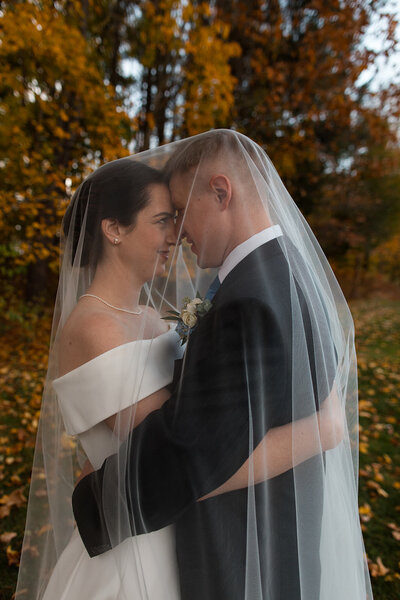 Bride and groom under bride's veil