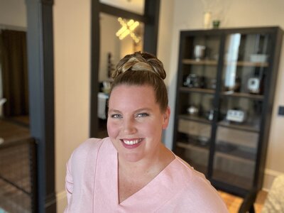 Sarah standing in front of a bookshelf smiling