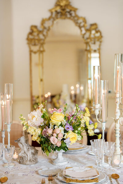 wedding reception table decorated with flowers and candles and fine china