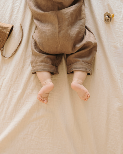 baby laying on their stomach on a beige blanket