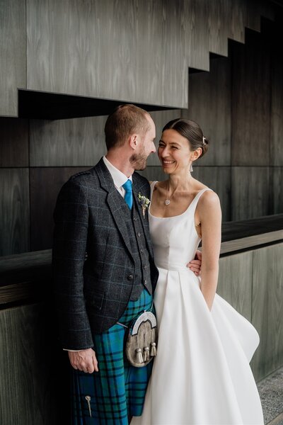 A wide photograph of a couple posing for wedding portraits in Aberdeen Art Gallery.
