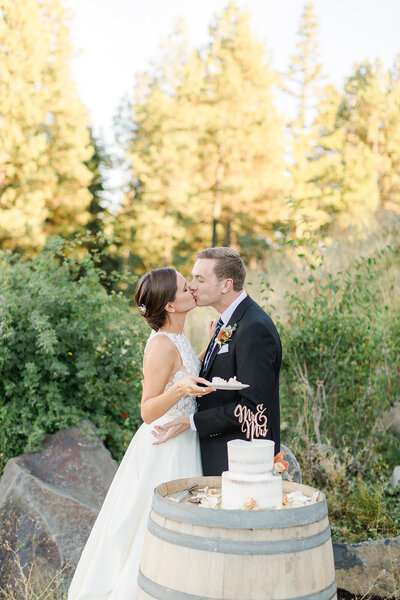 bride and groom kiss after cake cutting