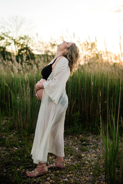 Maternity Photographer, pregnant woman standing outside holding her belly