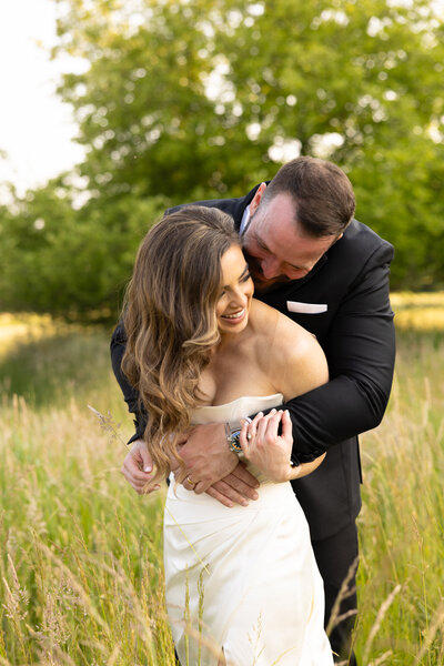 An Ohio bride and groom embrace one another during their couples portraits on their wedding day in Bracesville, Ohio. A true love story. Friends of more than 20 years before dating. And now finally happily married! Photo taken by Cleveland Wedding Photographer Aaron Aldhizer