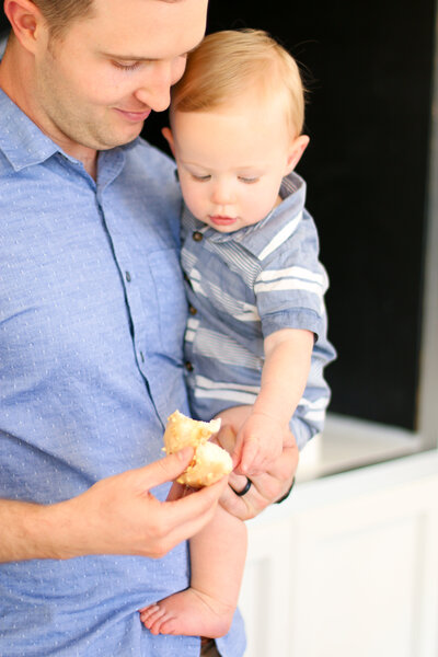 Dad holds his son as they eat donuts - Restoration