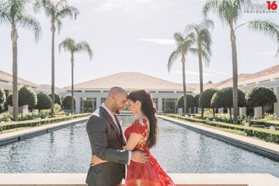 Engaged couple share a tender moment  in front of the reflection pool at the Richard Nixon Presidential Library