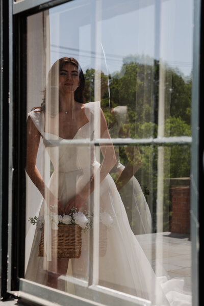 A reflective image of a bride in a window.