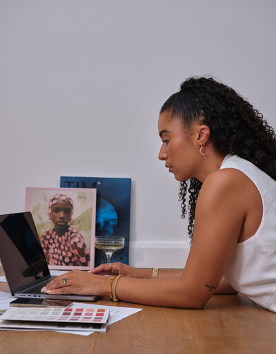 Woman sat on the floor working on a laptop