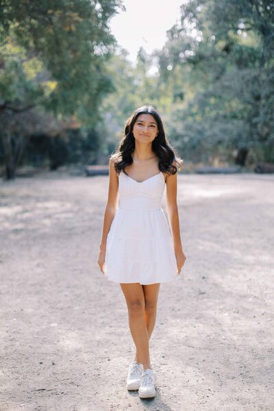 palo alto senior girl wearing a white dress and smiling at the camera