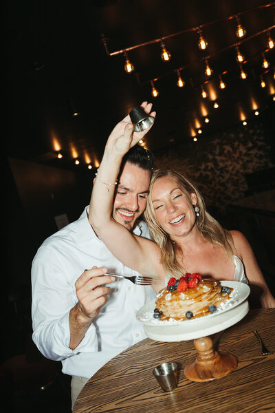 bride and groom putting syrup on pancakes