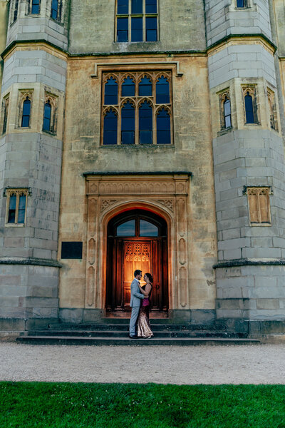 engaged couple looking at each other in front of the  main door at Ashon Court