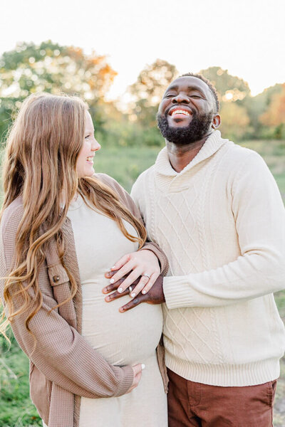Pregnant woman and her husband laugh together