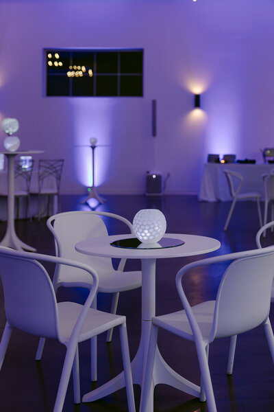 purple and blue lighting with white funky furniture