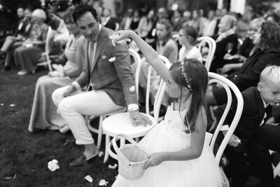 flower girl tosses petals during a wedding ceremony in prince edward county at a venue called the Brighthouse Farm. These PEC wedding photos were lovingly captured by Prince Edward County photographer Jennifer van Son