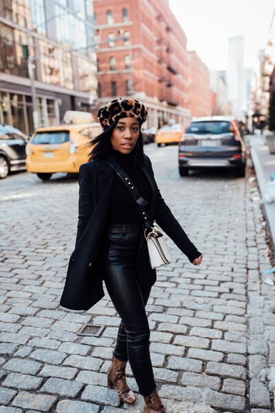 fashionable girl wearing all black walking on a busy New York street