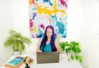 Heidi Thompson sitting at desk working on her laptop