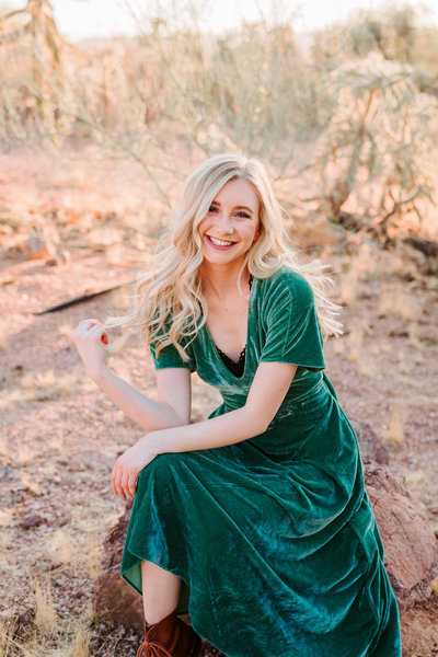 blonde high school  senior in field wearing green velvet dress