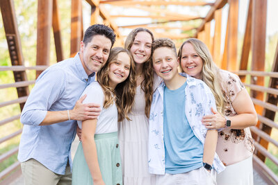 family with older kids hugging for family session