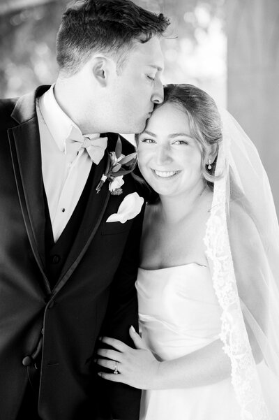 groom kissing bride on the head