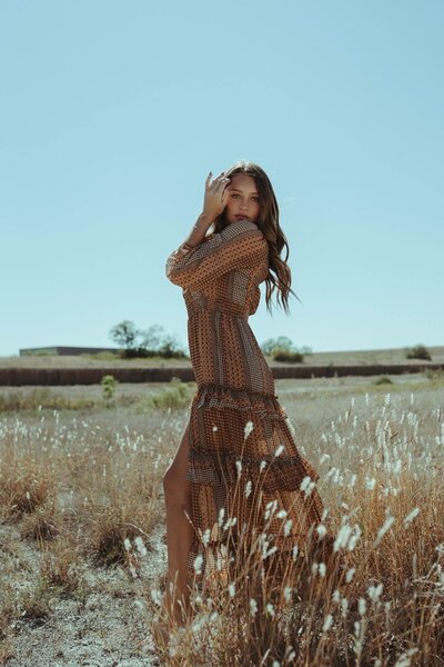 Model stand in a field wearing a patterned dress