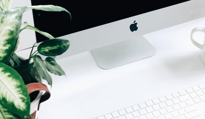 White desk with iMac, plant and keyboard