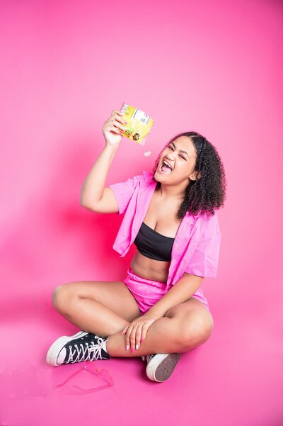 colorful photo shoot pink baackground girl dressed in pink eating candy