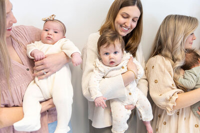 Group of moms holding their babies during a play date