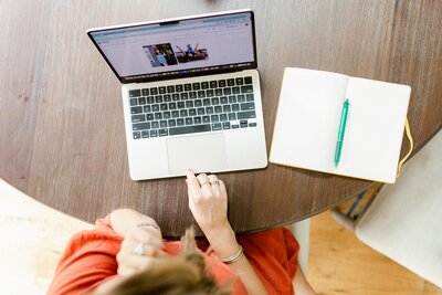 ng up heOverhead shot of Jennifer working on her laptop at her kitchen table with her notebook| Health and Mindset Coach for Women and Moms