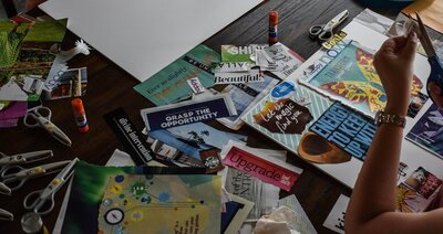 woman using scissors and magazines to create a vision board project