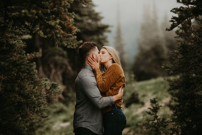 woman kisses her fiance during their engagement photography session in Paradise in Mount Rainier